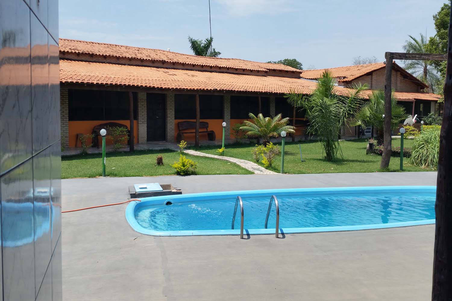 Pool und Fläche zum Relaxen neben Hotel